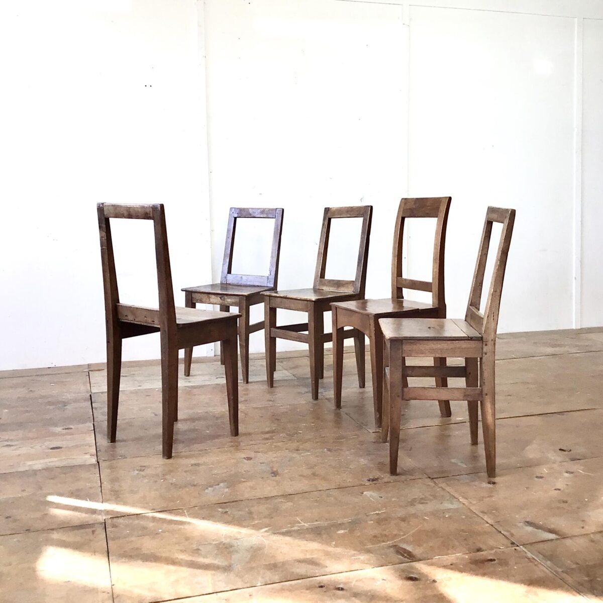 5 er Set Nussbaum Stühle mit markanter Alterspatina. Klare geradlinige Form, ideal um die aufrechte Haltung zu bewahren. 