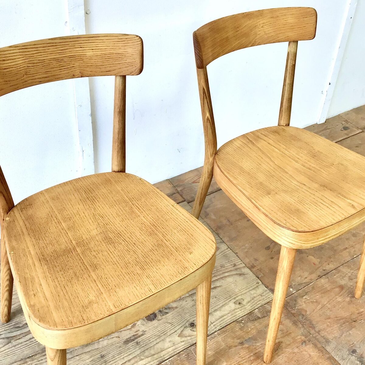 Zwei horgenglarus Stühle von Max Moser aus Eschenholz. Die Stühle sind stabil, Vorderbeine teilweise frisch eingeleimt. Komplett geschliffen und Natur geölt. Warm-matte honiggelbe Ausstrahlung, mit Alterspatina. 