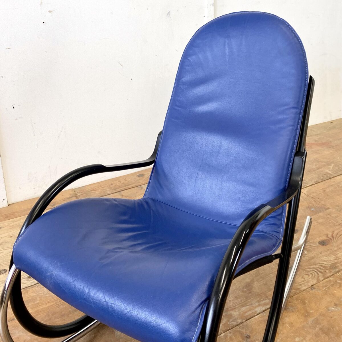 Deuxieme.shop midcentury Rocking Chair. Schweizer Schaukelstuhl von Paul Tuttle für Strässle 70er Jahre. Material blaues Leder, Buchenholz schwarz lackiert, und Metall verchromt. Ein paar altersbedingte Gebrauchsspuren, der Lack auf den Armlehnen hat ein paar kleinere Schrammen. Technisch in einwandfreiem Stabilen Zustand. Sitzhöhe 42cm, Breite 56cm, Tiefe 98cm, Gesamthöhe 94cm.