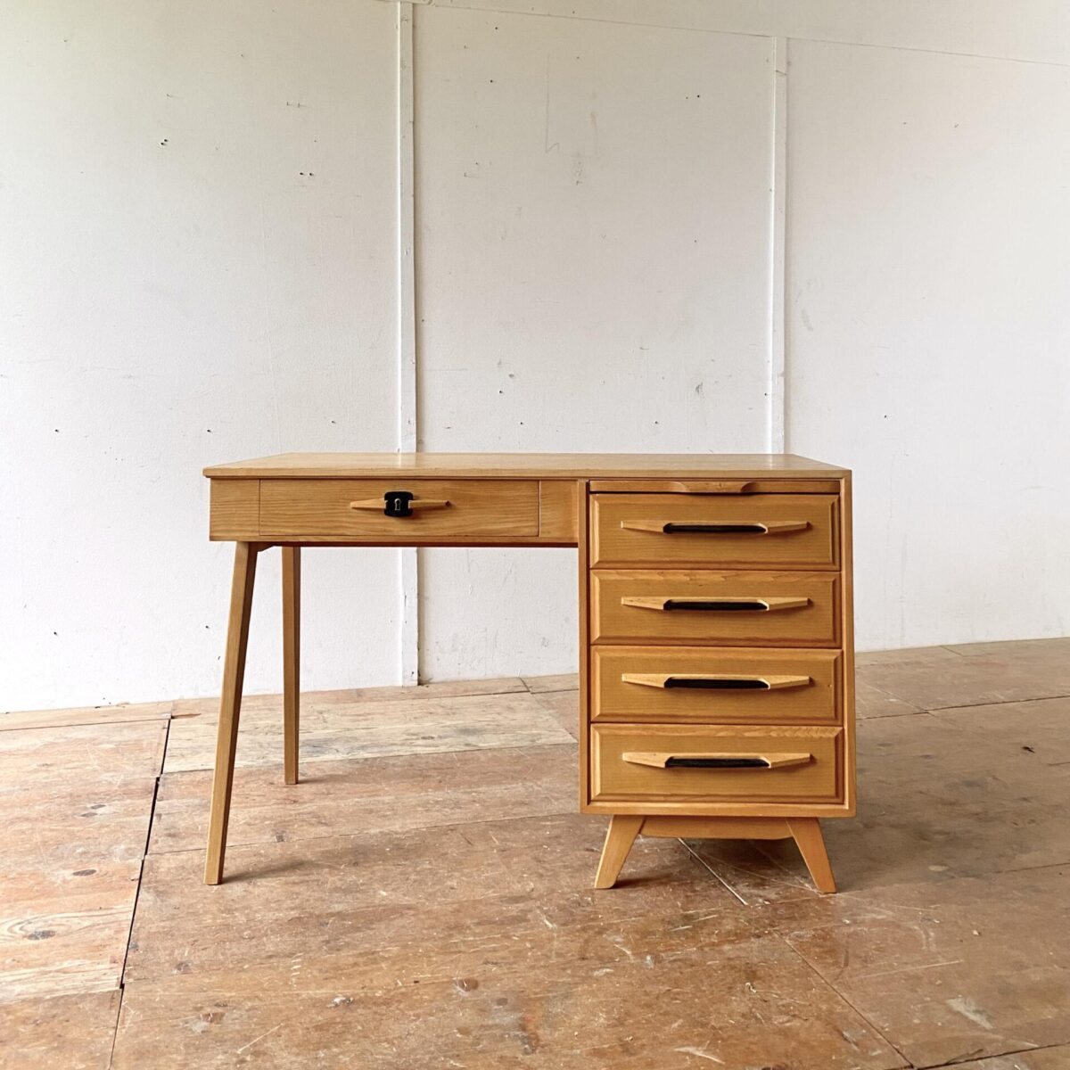 Deuxieme.shop midcentury Schreibtisch Swiss design. Heller Schreibtisch aus Eschenholz von Corta Multiform aus den 50er Jahren. 115x60cm Höhe 74cm. Der Tisch ist in gutem allgemein Zustand, die schwarzen Schubladengriffe sind aus Kunstleder. Der Schlüssel ist leider nicht mehr vorhanden. Der Stuhl ist ebenfalls verfügbar. 