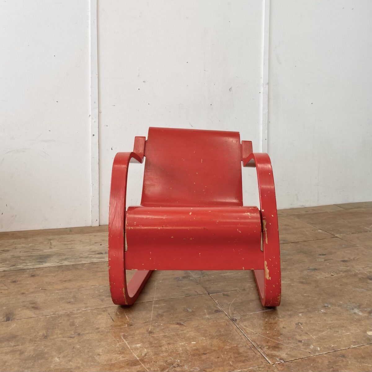 Deuxieme.shop Alvar Aalto Freischwinger Sessel. Modell 31 Birke Formsperrholz. Der Sessel ist etwas asymmetrisch (verzogen) was bei älteren Modellen öfters so ist. Im Bild 4 gut zu sehen. Die rote Farbe ist etwas abgewetzt, und mehrere Farbabplatzer an diversen Stellen. 