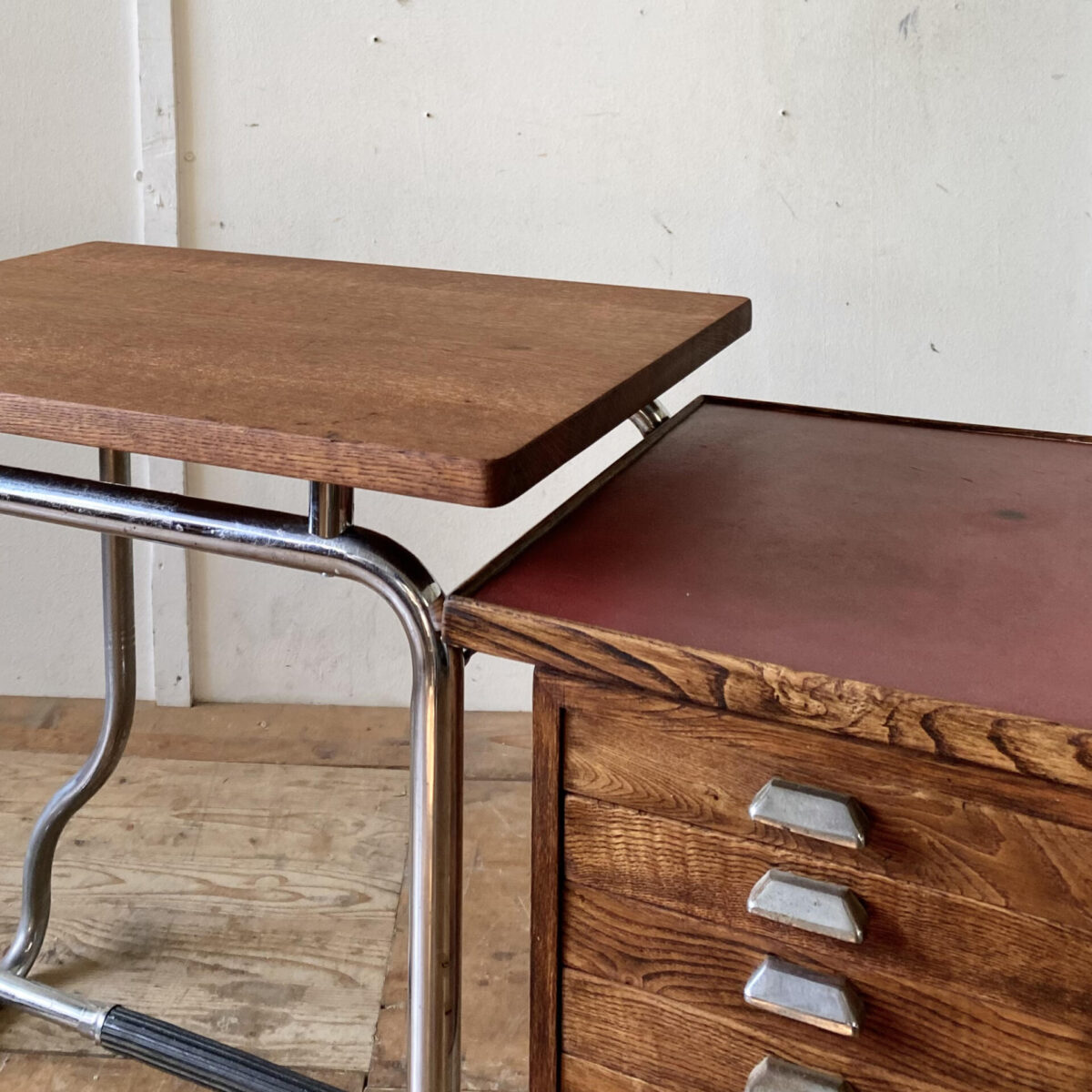 Deuxieme.shop Bauhaus Schreibtisch. Kleiner Schreibtisch aus Eichenholz mit Schubladen, auf gebogenem Stahlrohr Gestell. 127.5x47cm Höhe 71.5cm. Das Tischblatt ist aus Eiche Vollholz, die klappbare Seitenablage ist furniert. Die rechte rote Ablage ist aus Linoleum. Das verchromte Metallgestell hat etwas Flugrost und Patina. 