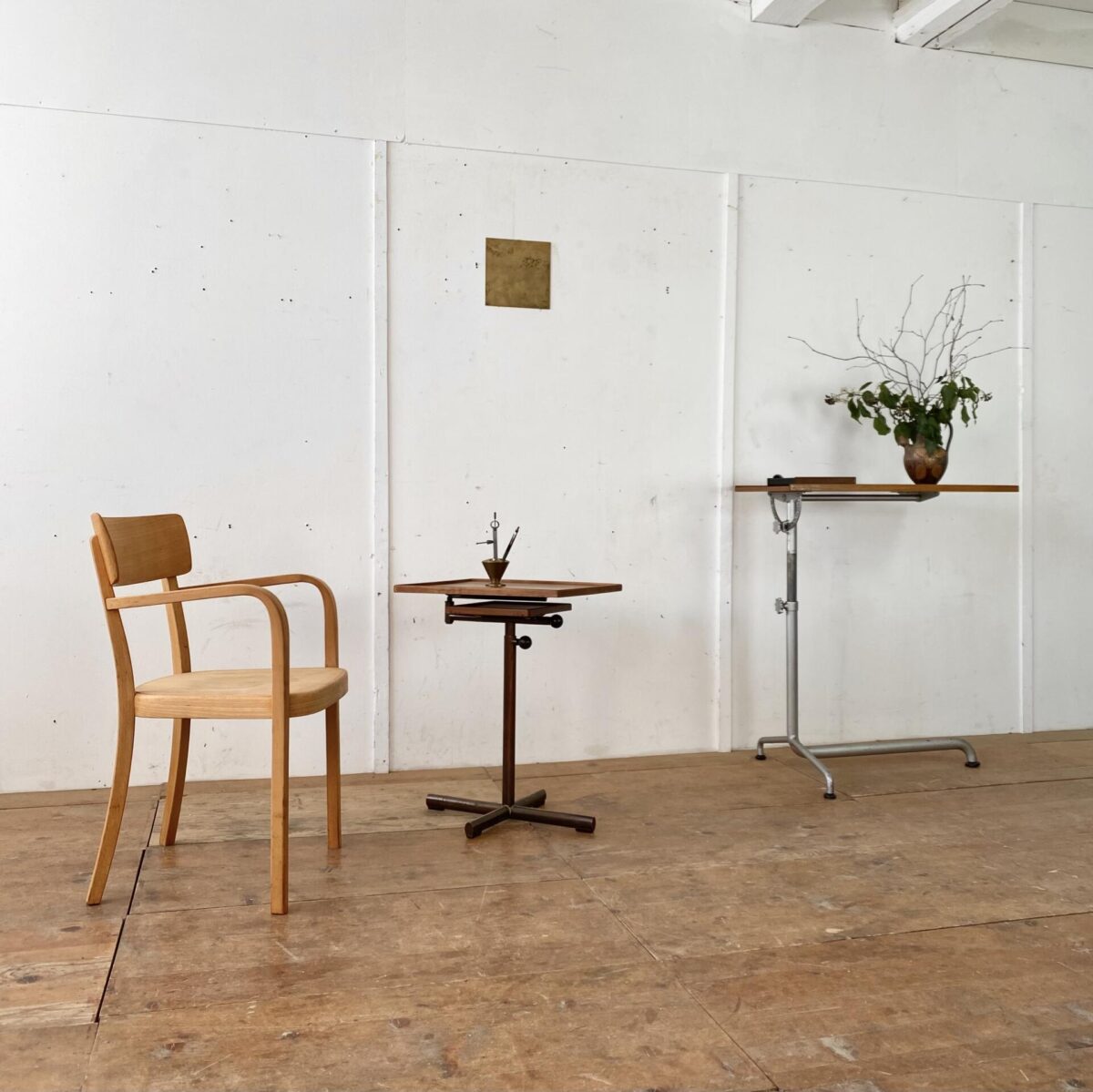 Deuxieme.shop Swiss designklassiker. Höhenverstellbarer Embru Tisch, von Georg Albert Ulysse Caruelle. Der Tisch ist höhenverstellbar von 70 bis 98cm. Die Hauptplatte ist Neigbar und misst 51.5x41.5cm. Das Metallgestell ist Kupferbrüniert, der eine fuss ist ausziehbar. Der Tisch kann vielseitig eingesetzt werden, als Betttisch, Sofa Beistelltisch, Notenständer oder als kleiner Arbeitstisch. Das Nussbaum furnierte Tischblatt hat eine kleine Luftblase bei genauer Betrachtung, ansonsten in schönem Vintage Zustand mit ein paar kleinen Wasserflecken und dem Tintenfass Ring. 
