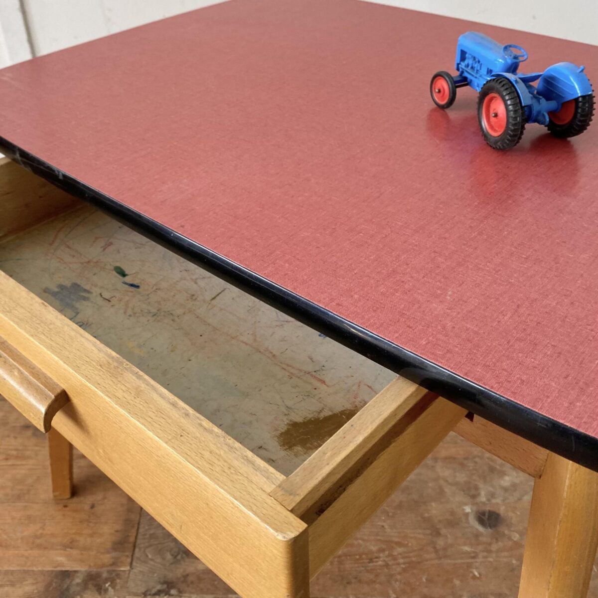 Deuxieme.shop 60er Jahre salontisch. Kinder Schreibtisch mit Schublade. 70x50cm Höhe 55cm. Buchenholz Unterbau mit konischen Schrägbeinen, das Tischblatt ist mit rotem Kunstharz (Kelko) belegt. 