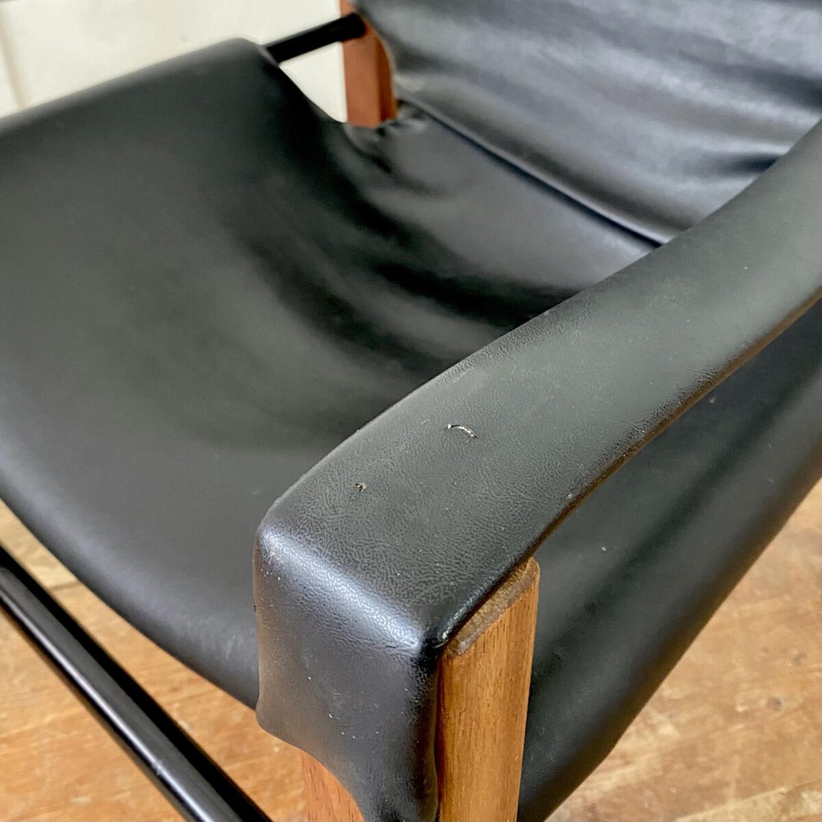 Deuxieme.shop Easy Chair Cocktail Sessel. Safari Sessel von Maurice Burke, hergestellt von Arkana in den 60er Jahren. 62x62cm Höhe 70cm Sitzhöhe ca. 30cm. Material, schwarzes Kunstleder (Vinyl). Die Lehne neigt sich mit der Sitzposition mit. Ein paar kleine Schäden im Bezug, und ein längerer oberflächlicher Kratz hinten, sind auf den Fotos dokumentiert. Das Teakholz ist in gutem Zustand mit leichten Gebrauchsspuren. 