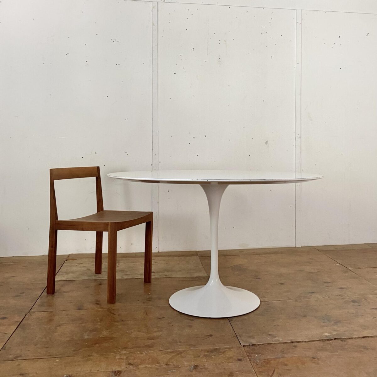 Deuxieme.shop Runder Tulpenfuss Tisch von Eero Sarinnen. Entwurf aus den 50er Jahren, hergestellt von Knoll International. Durchmesser 120cm Höhe 70.5cm. Das Tischblatt ist mit weissem Kunstharz beschichtet, die abgeflachte Tischkante ist lackiert.